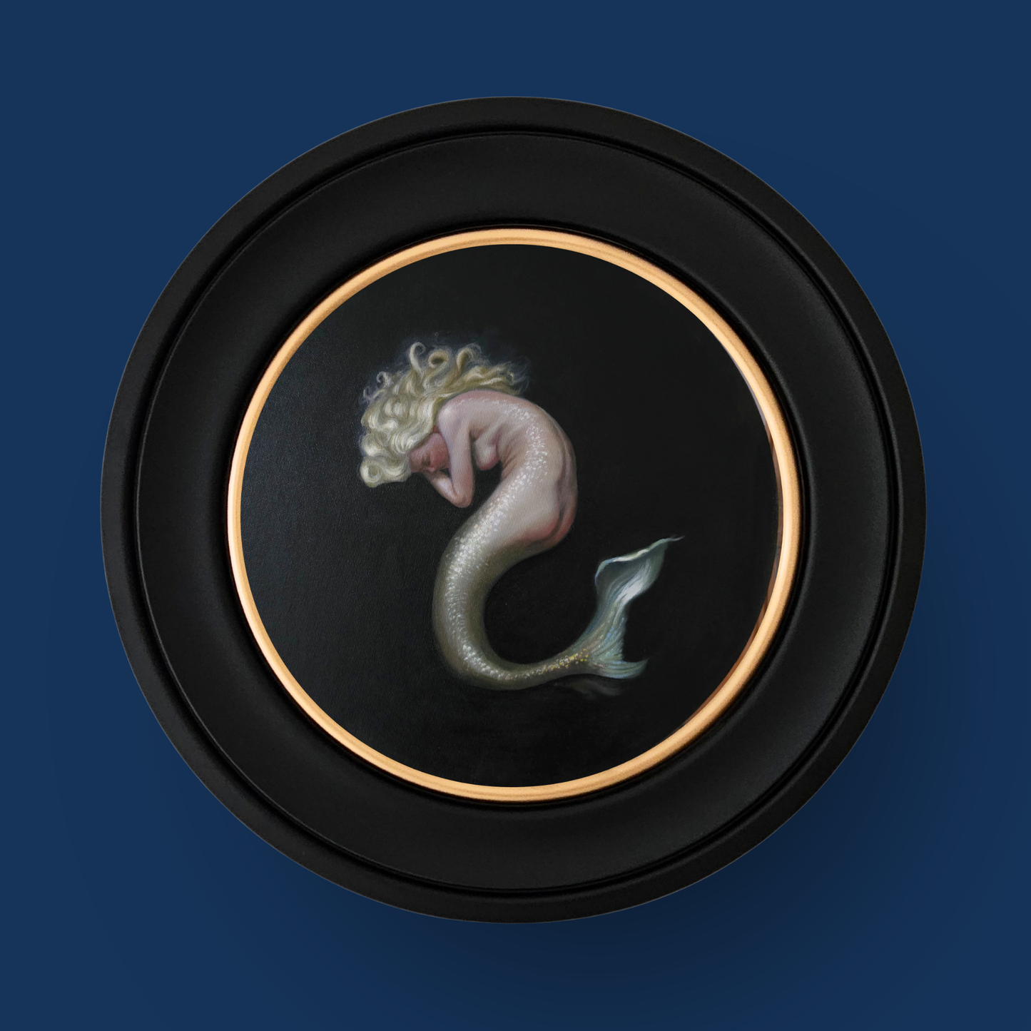 Mermaid artwork in a circular frame on a dark blue background