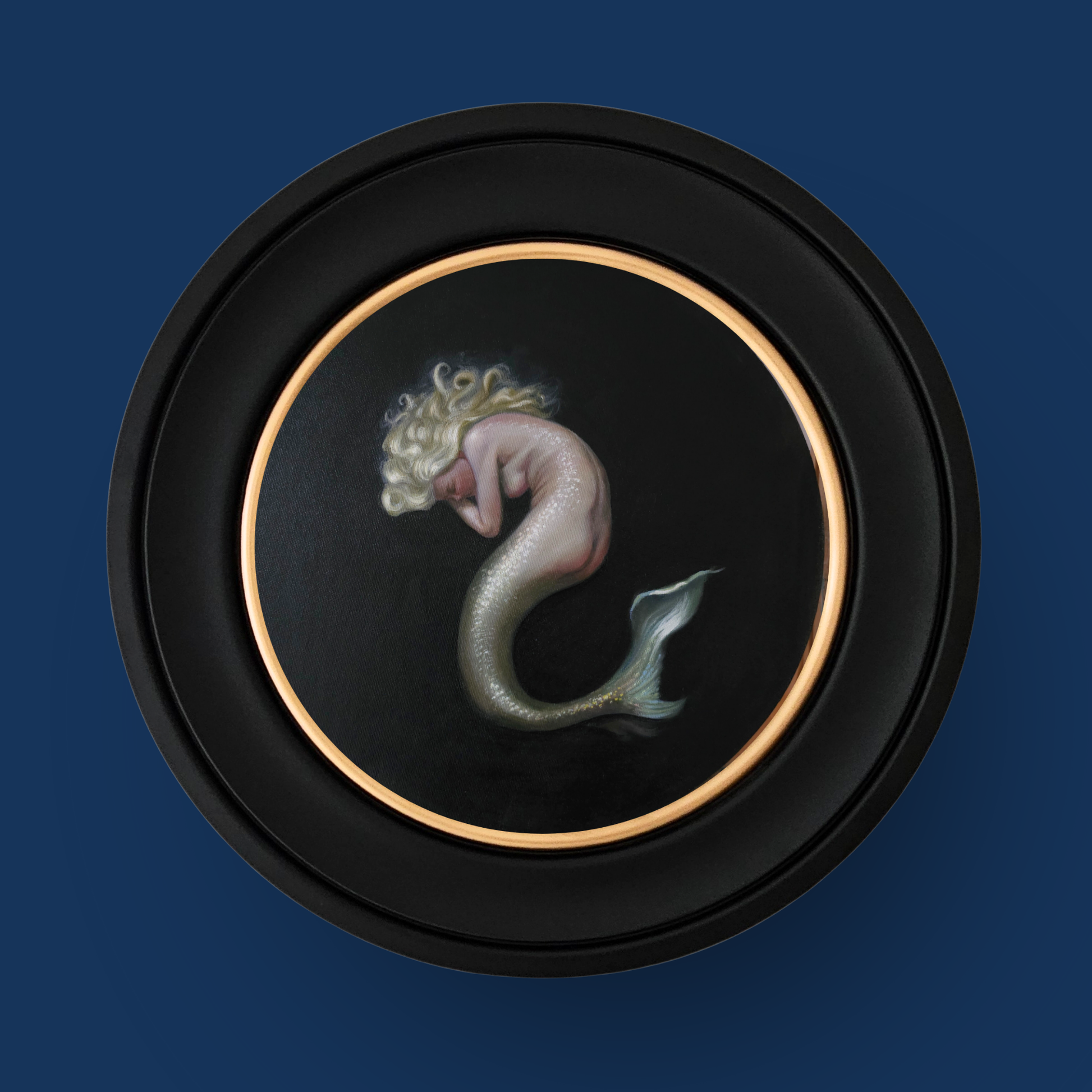 Mermaid artwork in a circular frame on a dark blue background